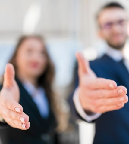 Dos personas ofreciendo un apretón de manos en un entorno profesional